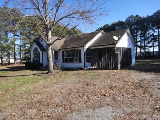 ranch-style home with a sunroom and a front lawn