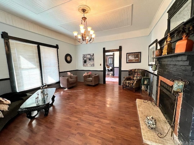 living room with a notable chandelier, a fireplace, dark hardwood / wood-style floors, and a healthy amount of sunlight