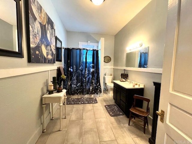 bathroom with toilet, tile floors, and vanity