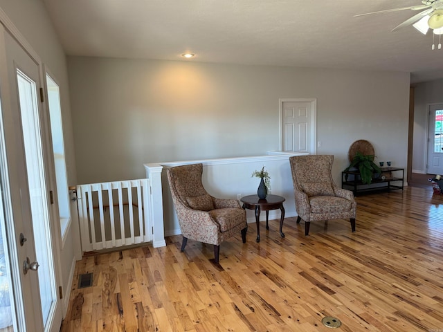 sitting room with ceiling fan and light hardwood / wood-style flooring