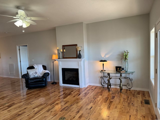 living room with ceiling fan, plenty of natural light, and light hardwood / wood-style floors