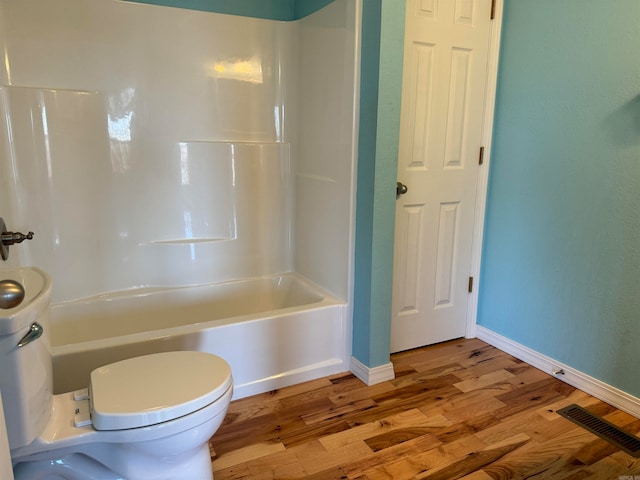 bathroom featuring shower / tub combination, toilet, and wood-type flooring