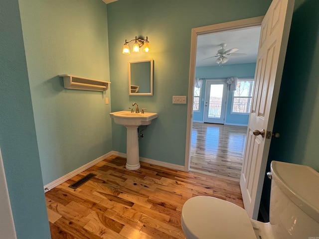 bathroom featuring toilet, ceiling fan, and hardwood / wood-style flooring