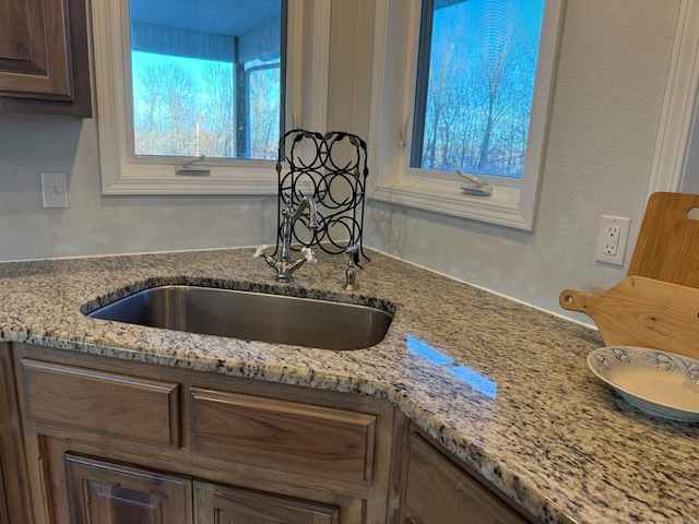 kitchen featuring sink and light stone countertops