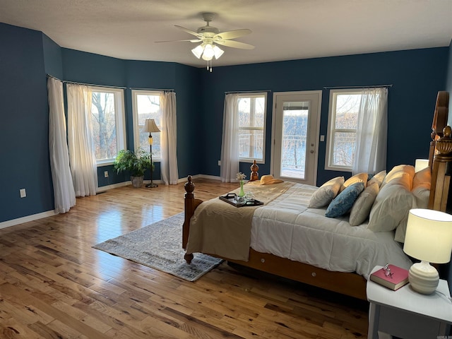 bedroom featuring hardwood / wood-style floors, ceiling fan, and access to outside