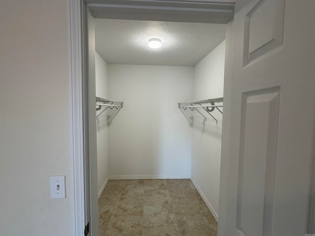 spacious closet with light tile floors