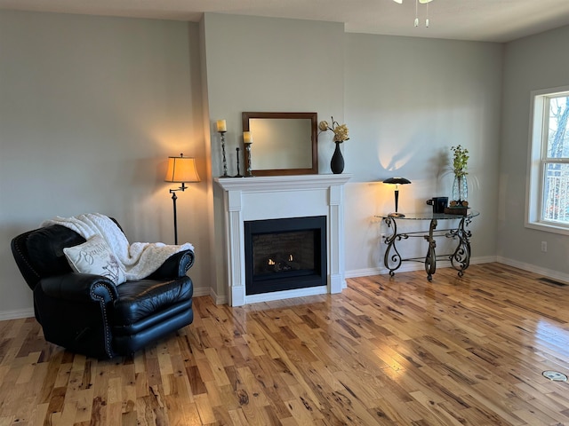 living area with ceiling fan and light hardwood / wood-style flooring