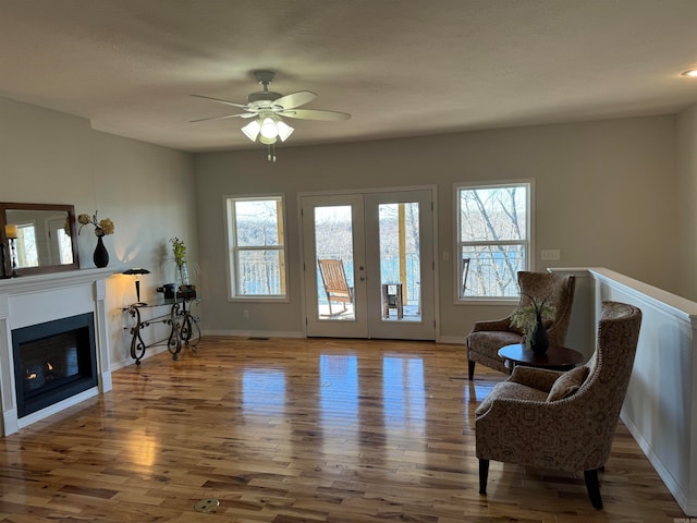 sitting room featuring ceiling fan, french doors, and wood-type flooring