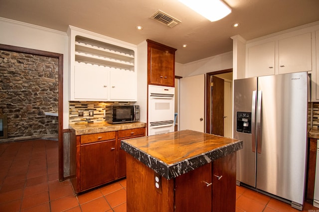 kitchen featuring stainless steel fridge with ice dispenser, backsplash, white double oven, a center island, and light tile floors