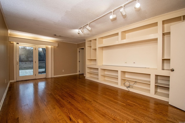 interior space featuring dark hardwood / wood-style flooring, built in features, rail lighting, a textured ceiling, and french doors