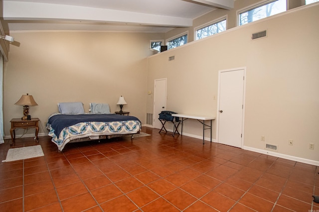 tiled bedroom with beamed ceiling and high vaulted ceiling