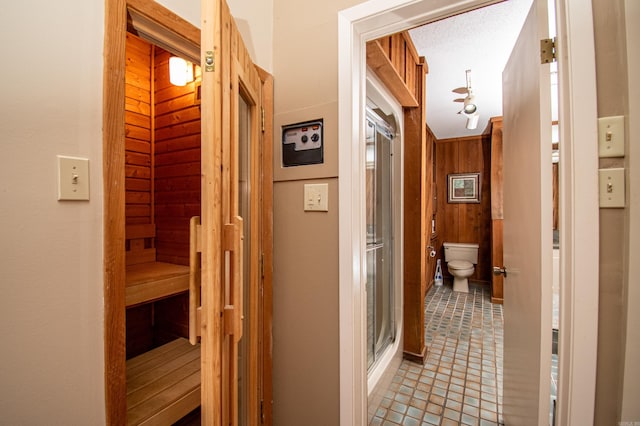 corridor featuring tile floors and wooden walls