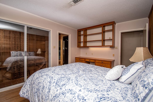 bedroom with a textured ceiling, a closet, wood-type flooring, and ornamental molding