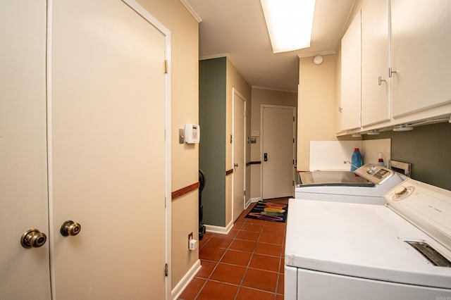 clothes washing area featuring cabinets, dark tile floors, ornamental molding, washer hookup, and washing machine and dryer