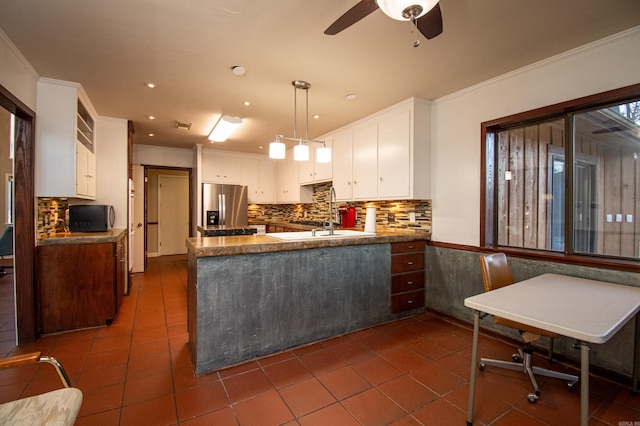 kitchen featuring tasteful backsplash, kitchen peninsula, stainless steel refrigerator with ice dispenser, and dark tile floors