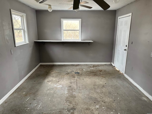 empty room with a textured ceiling, ceiling fan, and a wealth of natural light