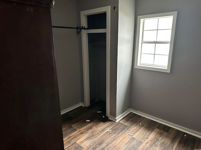 unfurnished bedroom featuring a closet and dark hardwood / wood-style floors