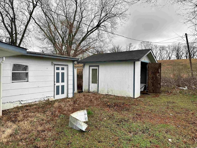 back of house with a storage shed