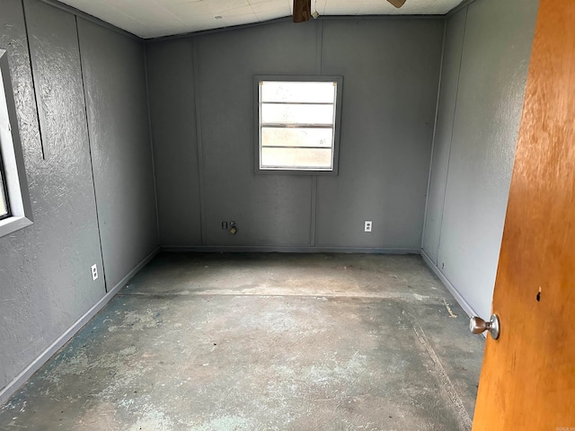 empty room featuring lofted ceiling, ceiling fan, and concrete floors