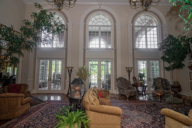 living room featuring hardwood / wood-style floors, a notable chandelier, french doors, and crown molding