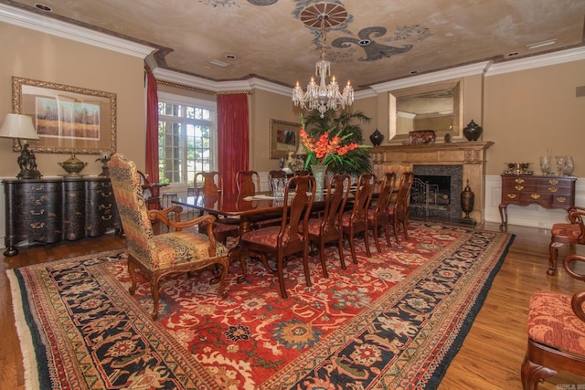 dining area with crown molding, a notable chandelier, and hardwood / wood-style flooring