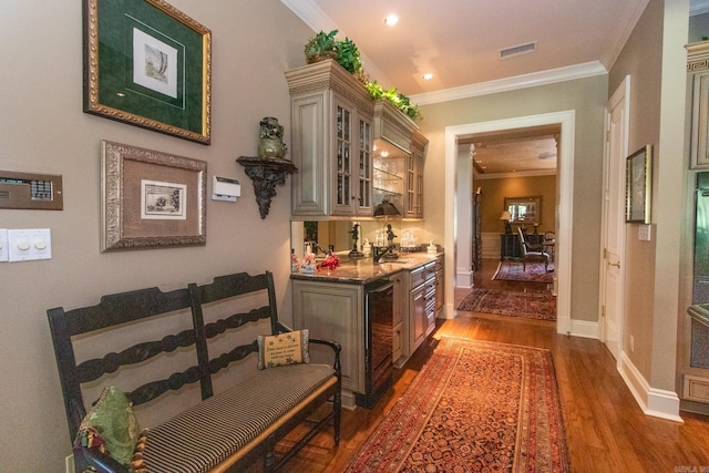 hall featuring ornamental molding, dark wood-type flooring, and beverage cooler