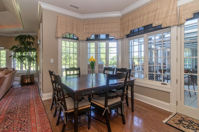 dining area with ornamental molding and dark wood-type flooring