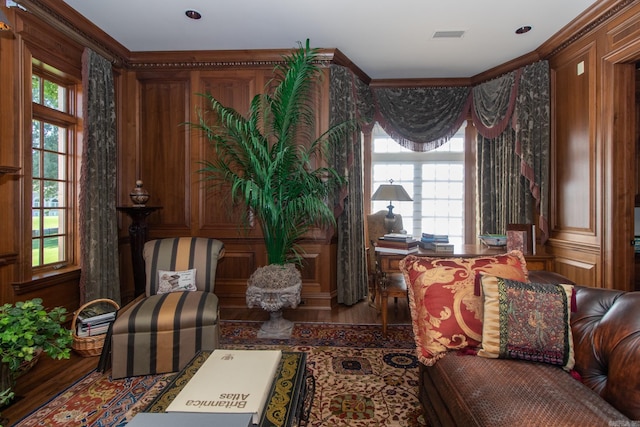 living area featuring hardwood / wood-style floors and crown molding