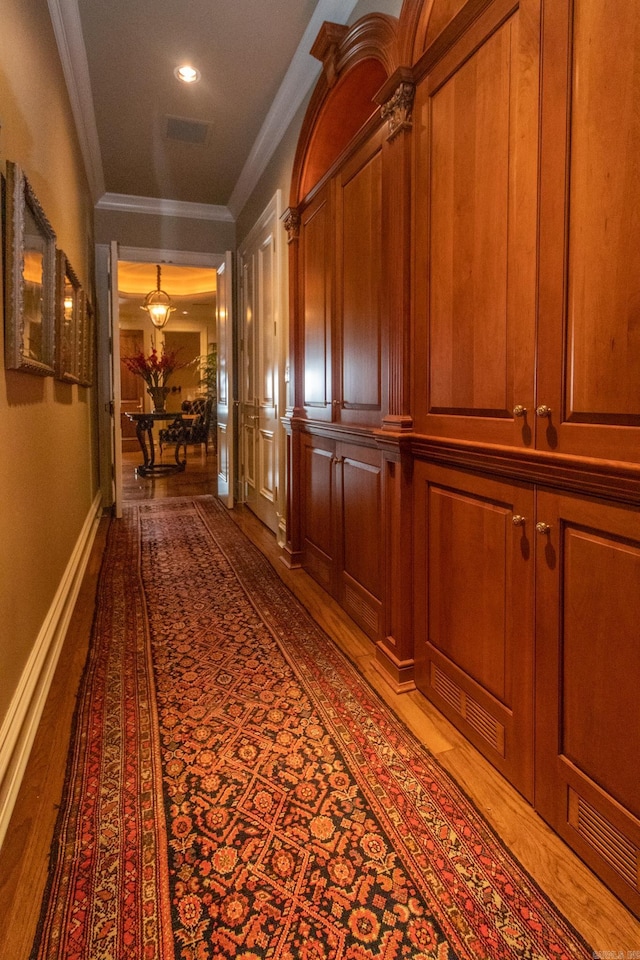 hall featuring ornamental molding and light hardwood / wood-style floors