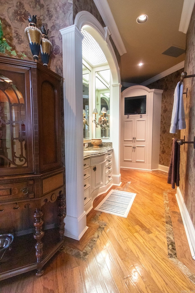 bathroom with ornate columns, vanity, wood-type flooring, and crown molding