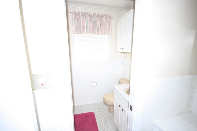 bathroom with tile walls, toilet, vanity, and tile flooring