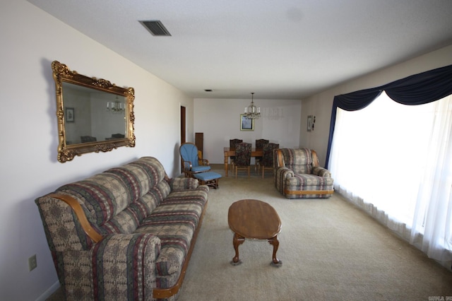 carpeted living room with a notable chandelier