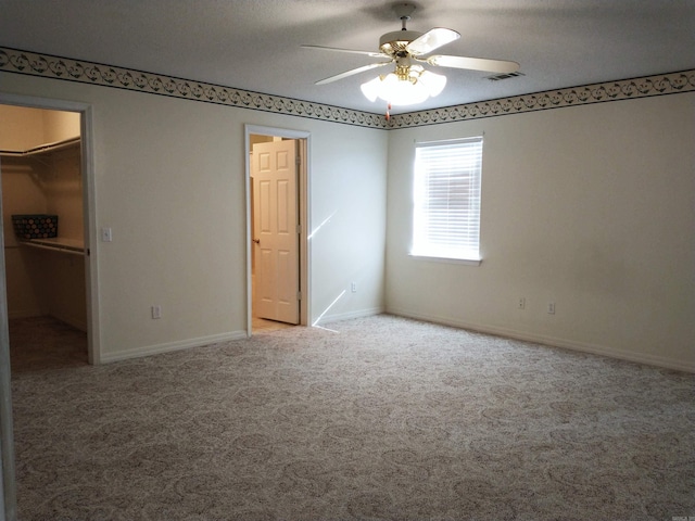 unfurnished room featuring carpet floors, ceiling fan, and a textured ceiling