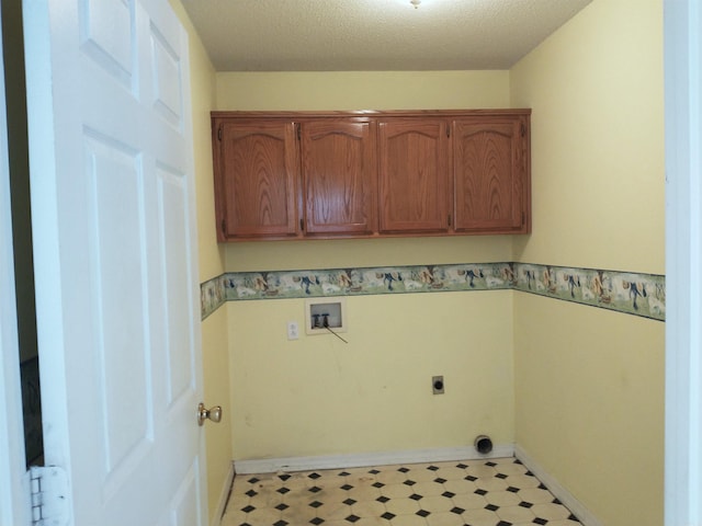 laundry room featuring light tile floors, hookup for a washing machine, electric dryer hookup, a textured ceiling, and cabinets