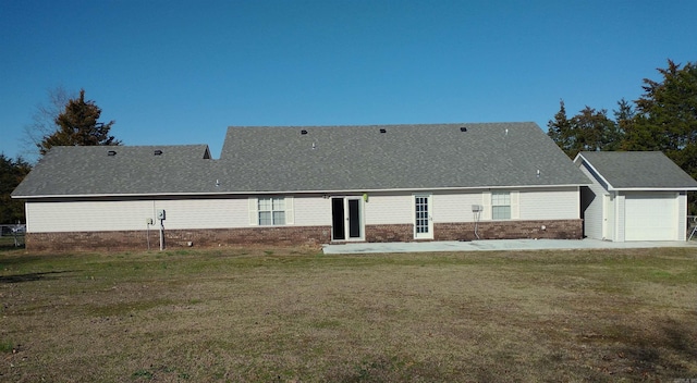 rear view of house with a garage and a yard