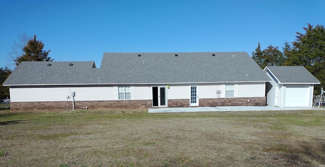 rear view of property with a yard and a garage