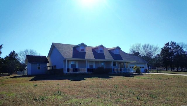 cape cod home featuring a porch and a front lawn