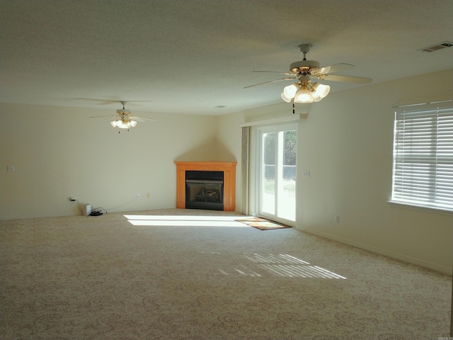 unfurnished living room with carpet floors and ceiling fan