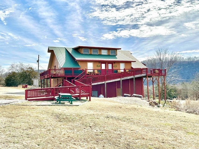 view of front of property featuring a deck and a front lawn