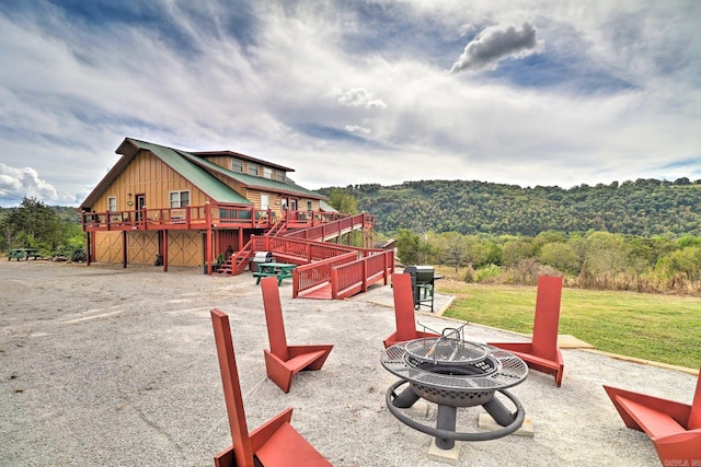 view of play area featuring a lawn, a fire pit, and a deck