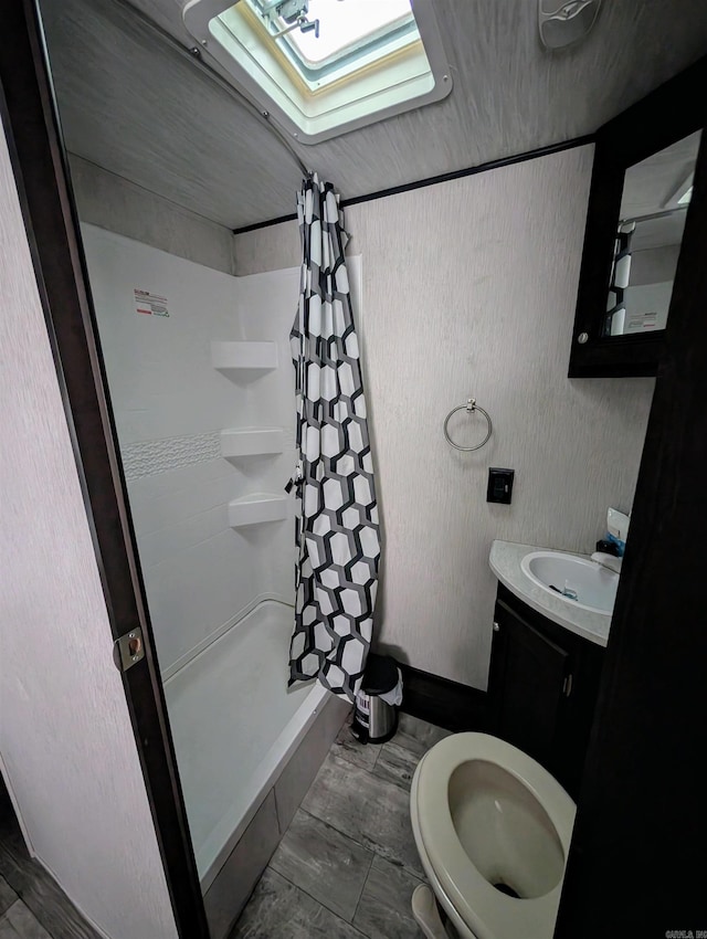 bathroom featuring curtained shower, vanity, and toilet