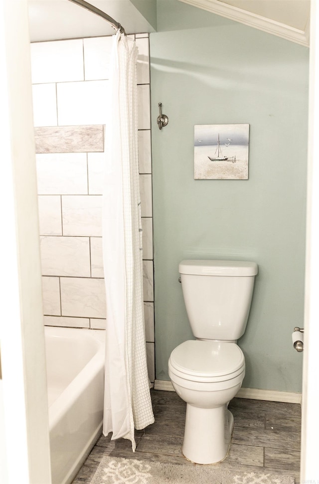 bathroom featuring hardwood / wood-style flooring, toilet, crown molding, and shower / tub combo