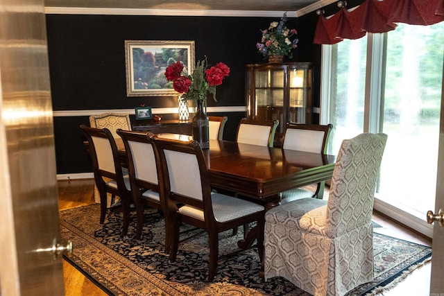 dining space featuring hardwood / wood-style floors and crown molding