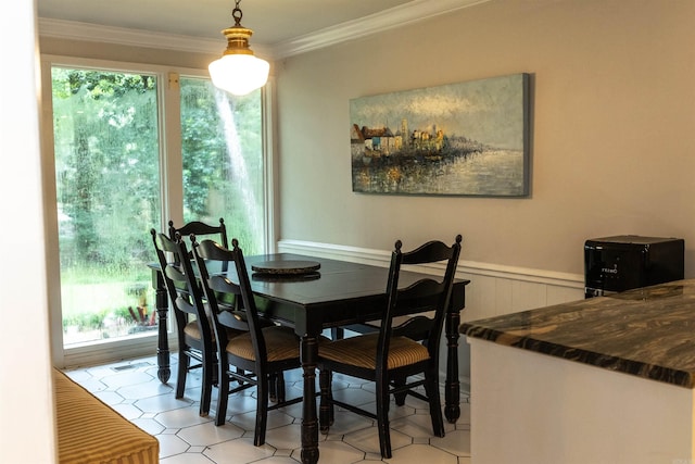 dining room with ornamental molding and a healthy amount of sunlight