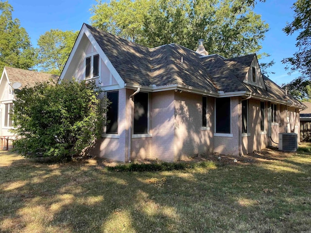 exterior space with a lawn and central AC unit