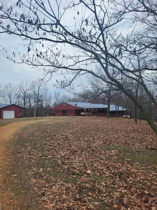 view of yard featuring an outbuilding, a garage, and an outdoor structure