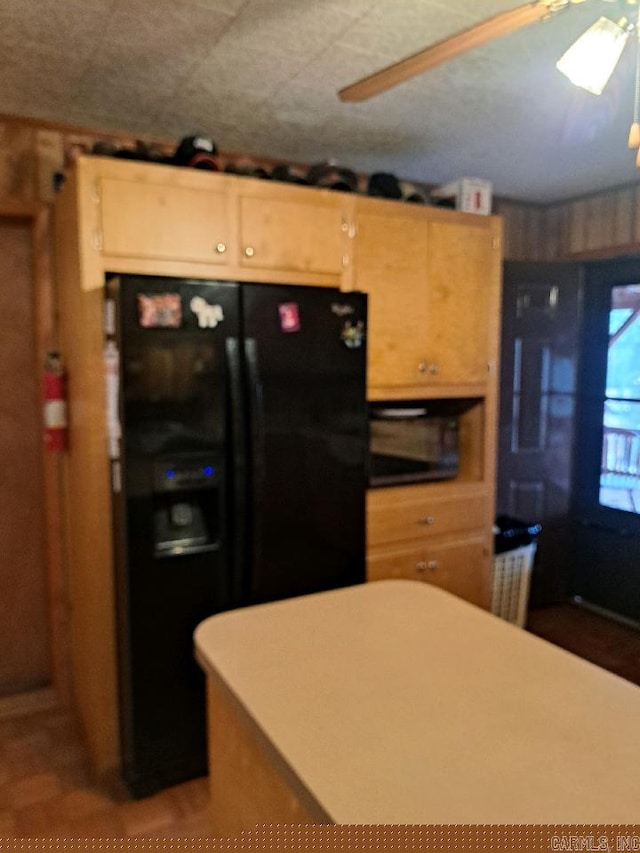 kitchen featuring light countertops and black refrigerator with ice dispenser