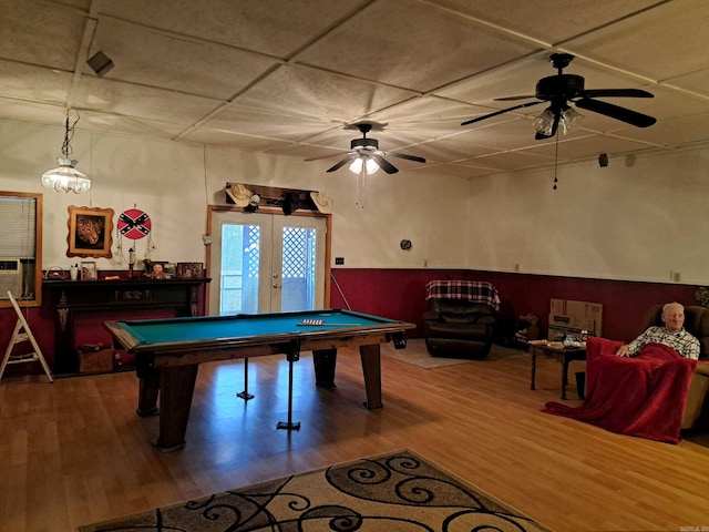 game room with wood finished floors, a drop ceiling, ceiling fan, pool table, and french doors