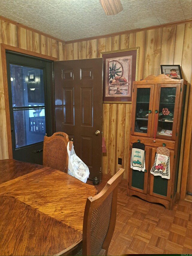 dining room featuring wooden walls and a textured ceiling