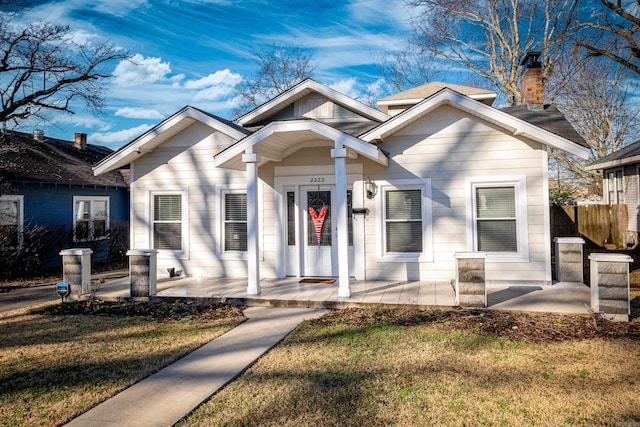 view of front of house featuring covered porch and a front lawn